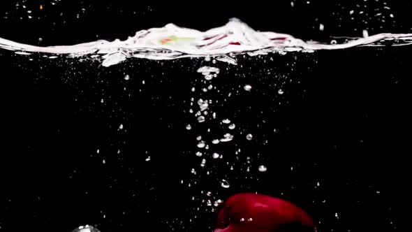 Slow Motion. Different fruits fall into the water