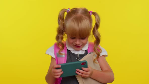 Worried Funny School Girl Wear Backpack Enthusiastically Playing Racing Video Games on Mobile Phone