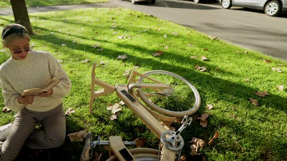 Female with Lumber Eco Bicycle Reading a Book