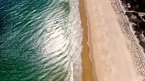 Tropical ocean and sandy beach with luxury town, aerial view