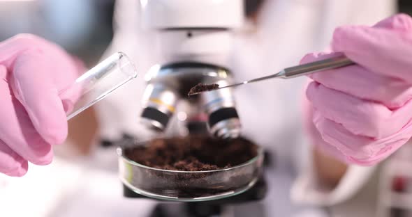 Researcher Holds Glass Flask with Earth in Hand Closeup