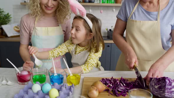 Zoom out of three generations of women preparation Easter eggs. Shot with RED helium camera 8K