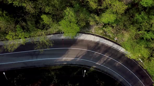 Top Down View of Winding Mountain Road with Cars