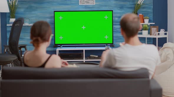 Static Tripod Shot of Couple Having a Snack While Looking at Green Screen Tv Watching a Movie
