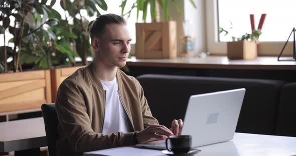 Man Finish His Work with Laptop PC in a Cafe