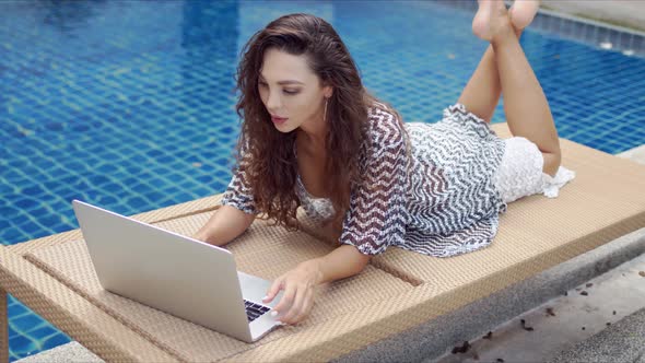 Focused Female Browsing Laptop Near Water