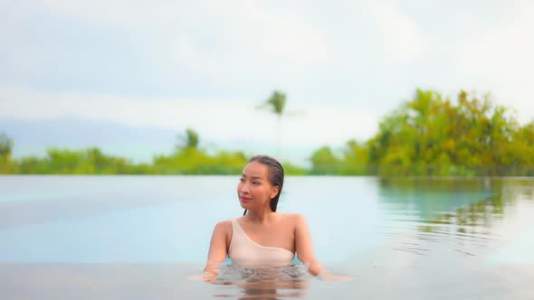 Young asian woman enjoy around outdoor swimming pool for leisure