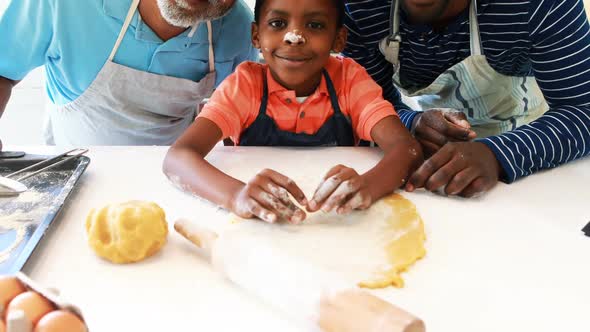 Multi-generation family with flour on the nose standing in the kitchen