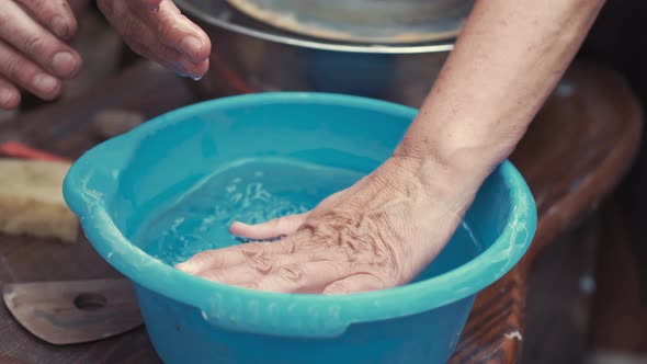 People Washing Their Hands in a Bucket