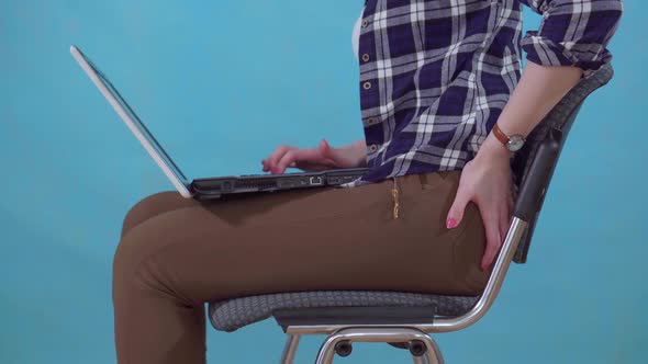 Woman Sitting Working on a Laptop Is Experiencing Pain and Discomfort From Hemorrhoids Close Up