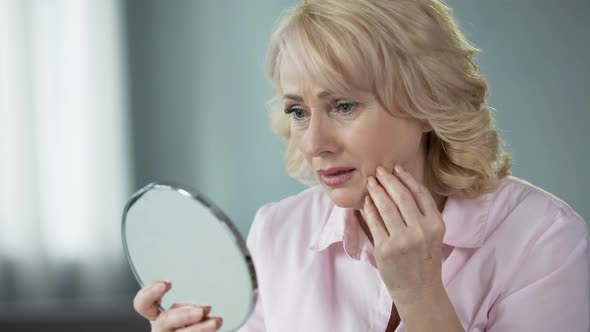 Sad Woman Looking at Face Reflection and Crying, Unhappy With Wrinkled Skin