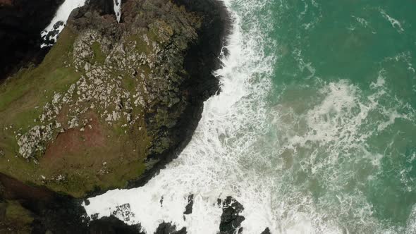 An aerial overhead orbit of the waves from the Atlantic crashing into the shores of Cornwall, Englan