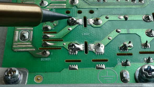 Close up shot electric solder in soldering on electronic print circuit board with hot lead