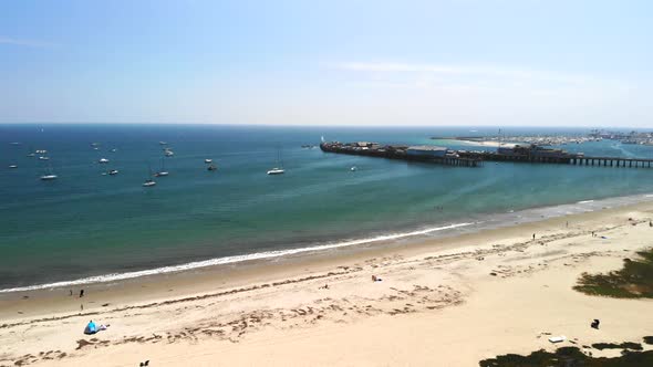 Aerial shot above Chase Palm Park looking out at sail boats anchored in the dark blue Pacific Ocean