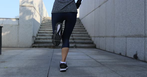 Fitness sports woman running up stairs in city