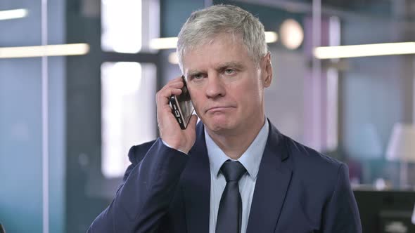 Portrait of Middle Aged Businessman Talking on Cellphone