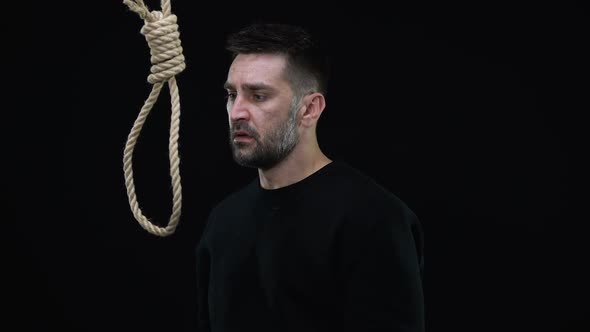 Desperate Male Putting Rope Loop Over Neck Black Background, Committing Suicide