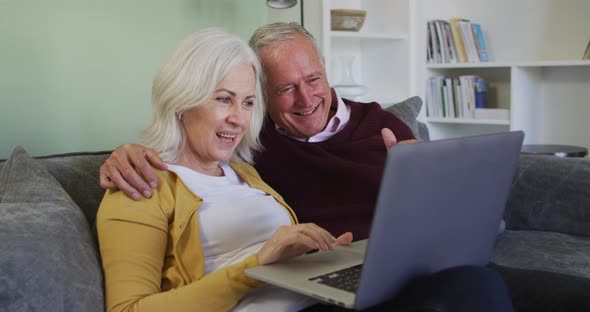 Happy senior caucasian couple making video call using laptop computer