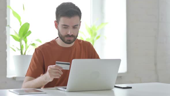 Young Man Shopping Online on Laptop