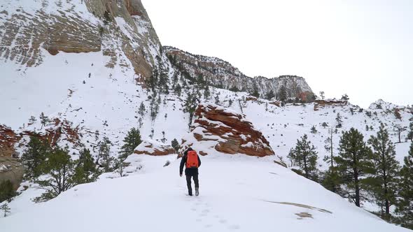 Man hiking through snow in Zion National Park