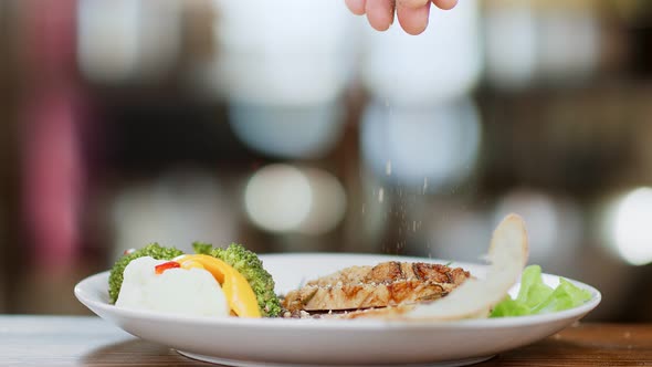 Close Up Chef Hand Sprinkle Salt and Seasoning on Meat Piece Slow Motion