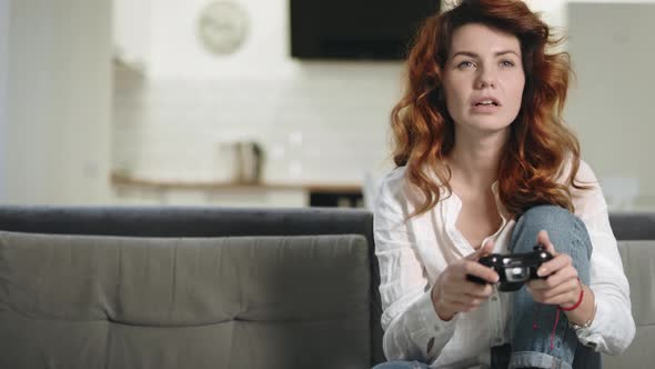 Crazy Woman Playing Video Game at Home Kitchen. Pretty Girl Holding Play Station