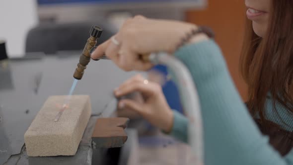 Unidentified Artisan Jeweler Working And Heating Up A Small Metal Plate With Blow Torch