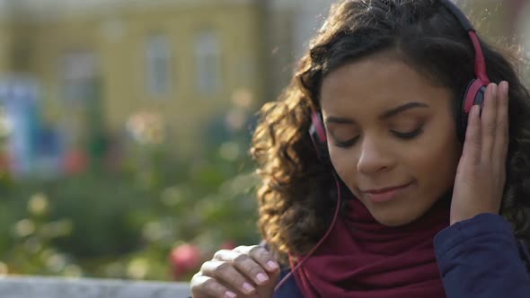 Close-Up of Happy Female in Headphones Listening Favorite Song Outdoors, Music
