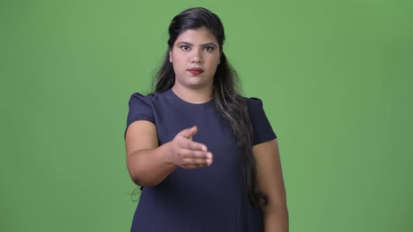 Young Overweight Beautiful Indian Businesswoman Against Green Background