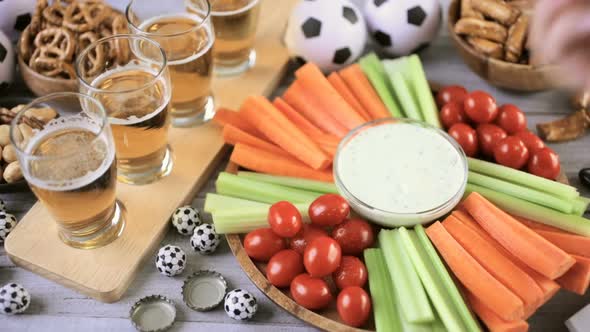 Draft beer and salty snacks on the table for soccer party.