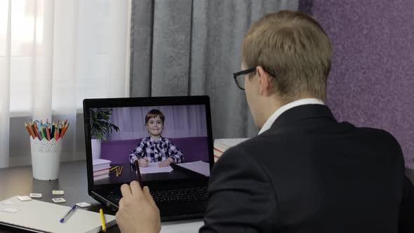 Man Teacher Makes Video Call on Laptop with Children Pupil. Distance Education