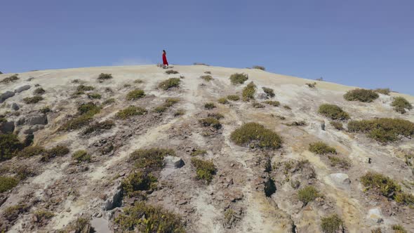Aerial View of Girl in Long Red Dress in Mountains