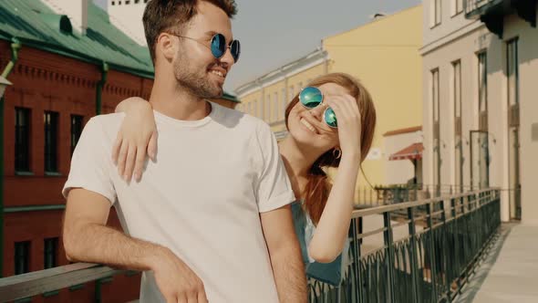 Portrait of smiling beautiful female and her handsome boyfriend posing outdoors