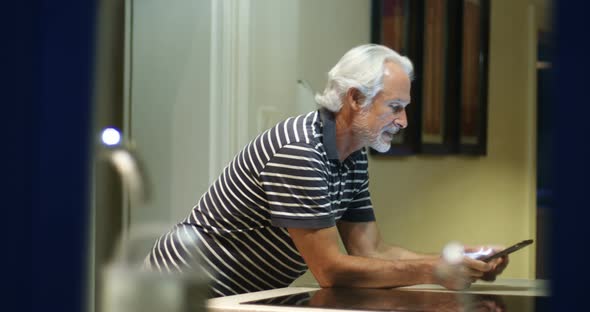 Senior man using digital tablet at home 4k