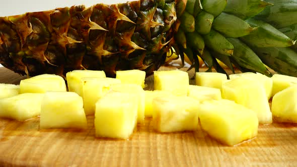 Pieces of pineapple on a cutting wooden board.