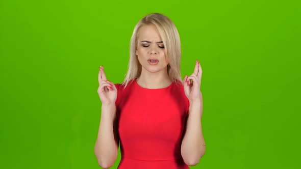 Woman Crosses Her Fingers in Two Hands for Good Luck