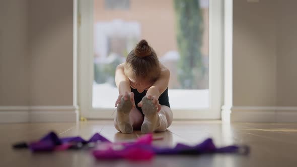 Front View Teenage Girl Bending Stretching Muscles Training Indoors in Slow Motion