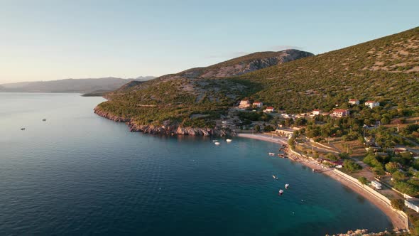 Aerial View of the Rocky Coast of Croatia with Camping and Curve Road at Sunset