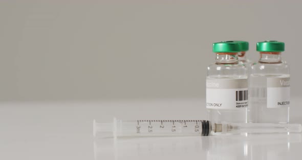 Video of close up of vaccine vials on white background