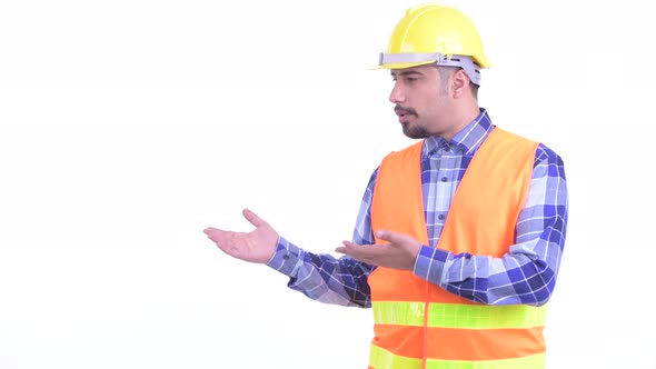 Happy Bearded Persian Man Construction Worker Talking While Showing Something