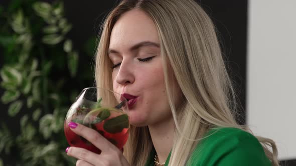 Blonde with Pleasure Drinking a Delicious Cocktail