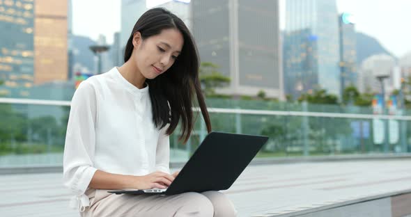 Business woman use of notebook computer at city