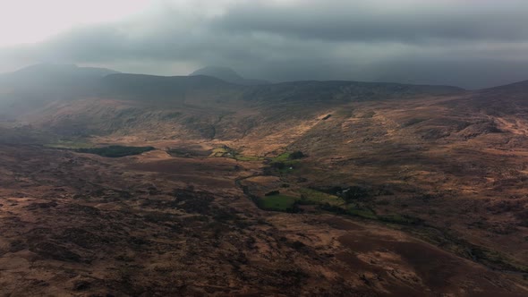 Killarney, Kerry, Ireland, March 2022. Drone pulls southeast towards Molls Gap under a moody sky wit