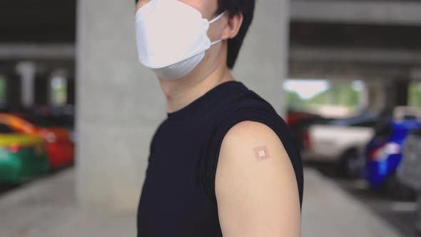 Vaccinated Man Showing Arms with Plaster Bandage After Receiving Covid19 Vaccine Injection