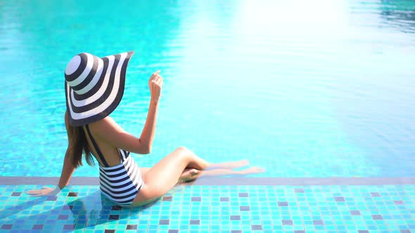 Young asian woman enjoy around outdoor swimming pool for leisure