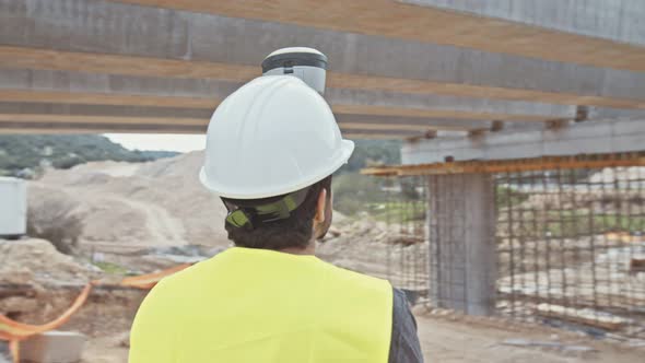 Construction engineer working with GPS equipment on a large highway construction site