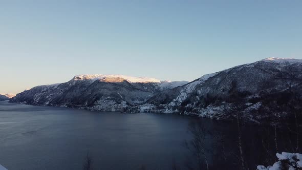 Aerial showing Vaksdal from Langhelle - Snowy landscape and fjords in early morning