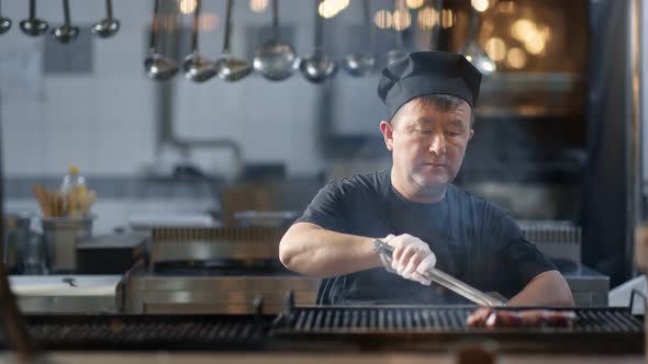 Asian Chef Roast on Grill Beef Steak Cooking at Restaurant