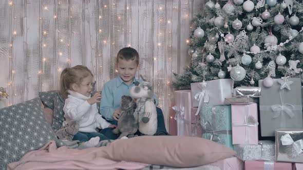 Cute Kid in Light Blue Shirt Entertains Younger Blond Sister