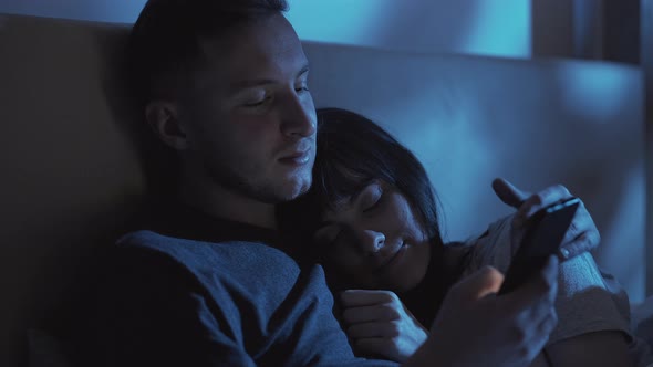 Cuddling Couple Gadget Night Using Phone in Bed